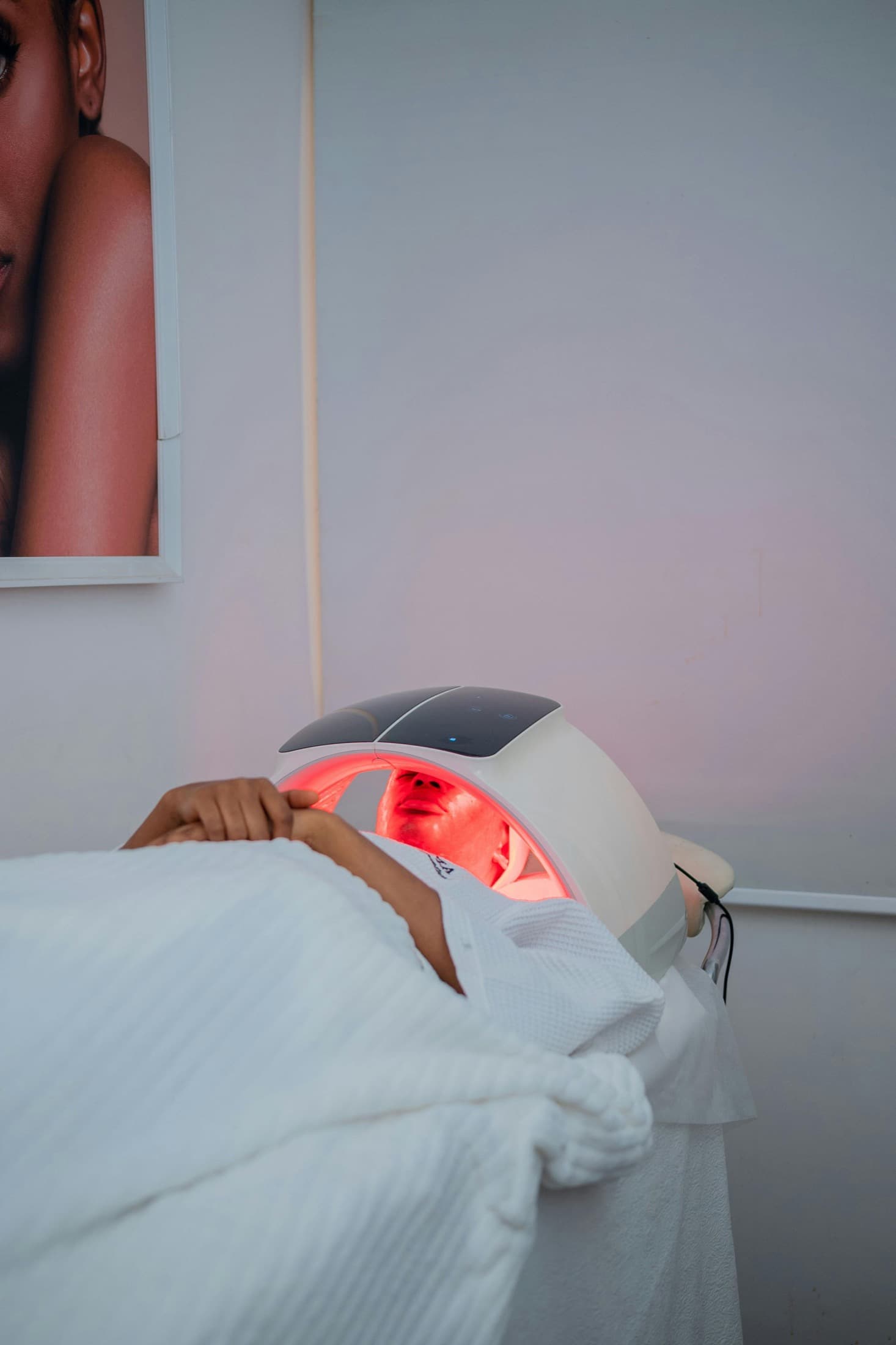 Client receiving red light therapy treatment in a modern wellness room.